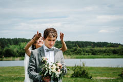 The first meeting is newlyweds on a green field outdoors. Bride goes back to the groom, surprise in nature. Happy wedding day of marriage.