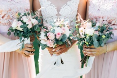Bride and bridesmaid are holding bouquets of flowers in hands. Wedding d etails.